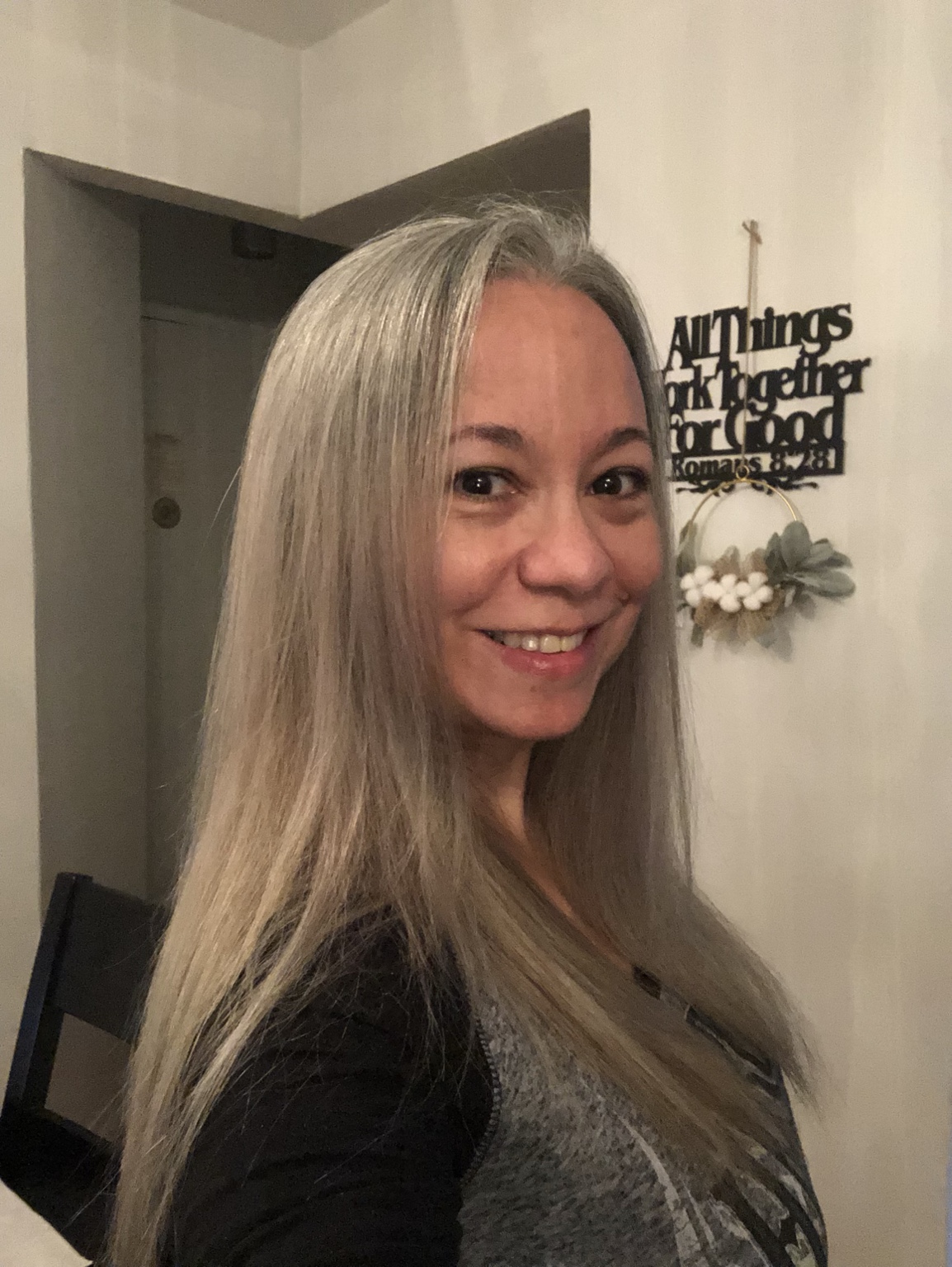 Ms. Sandy Roses smiling in a portrait with her long silver hair